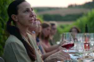 persone fanno aperitivo a base di vino in vigna