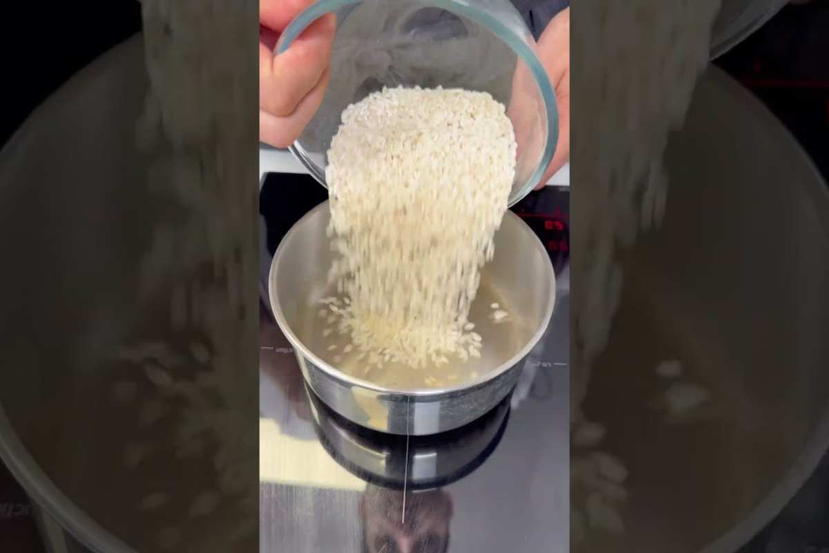una persona versa del riso in una pentola