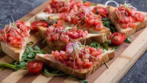 Bruschetta con pomodorini, rucola e pesto di zucchine