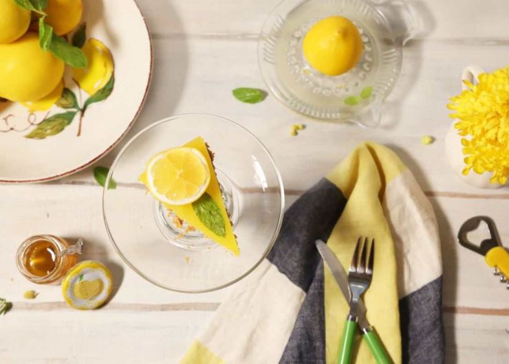 fetta di cheesecake al limone, limoni e posate