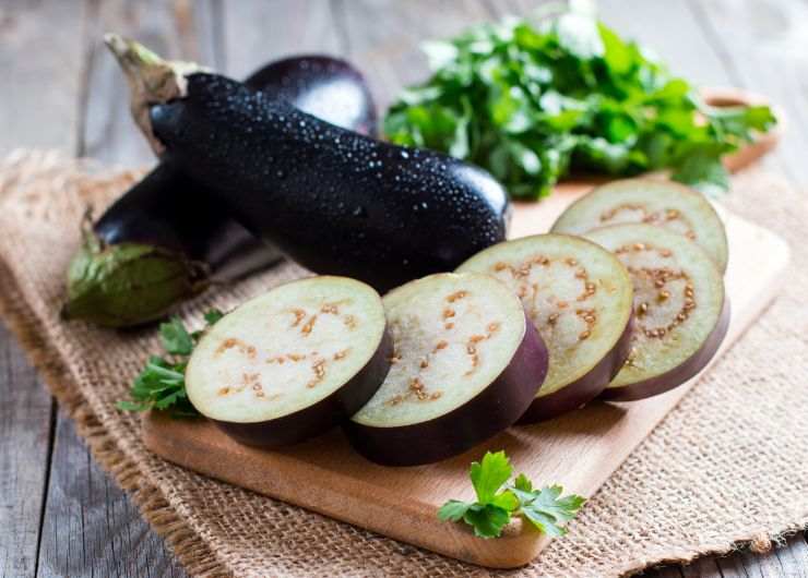 melanzane tagliate a fette su tagliere di legno