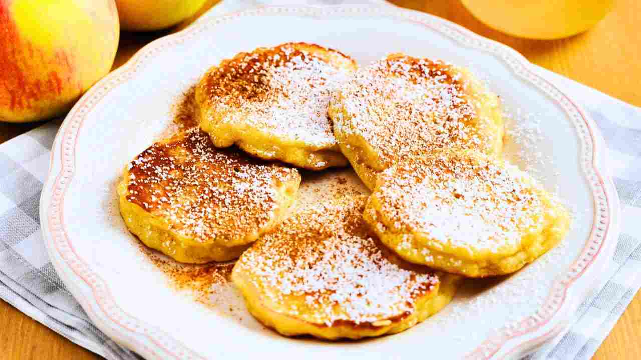 frittelle alle mele in un piatto con zucchero a velo