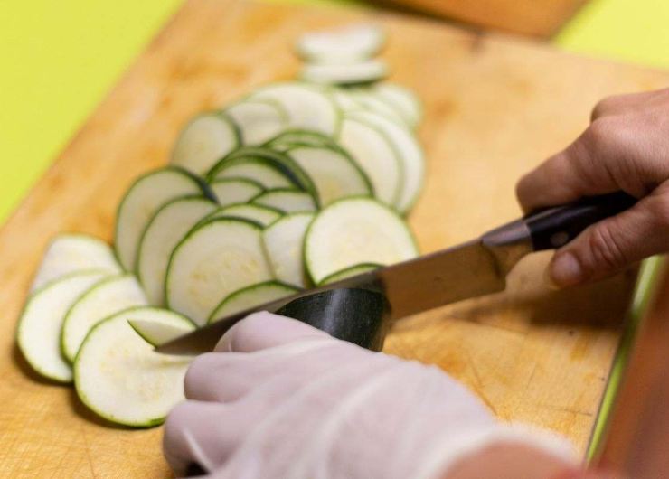 persona che taglia zucchine a rondelle